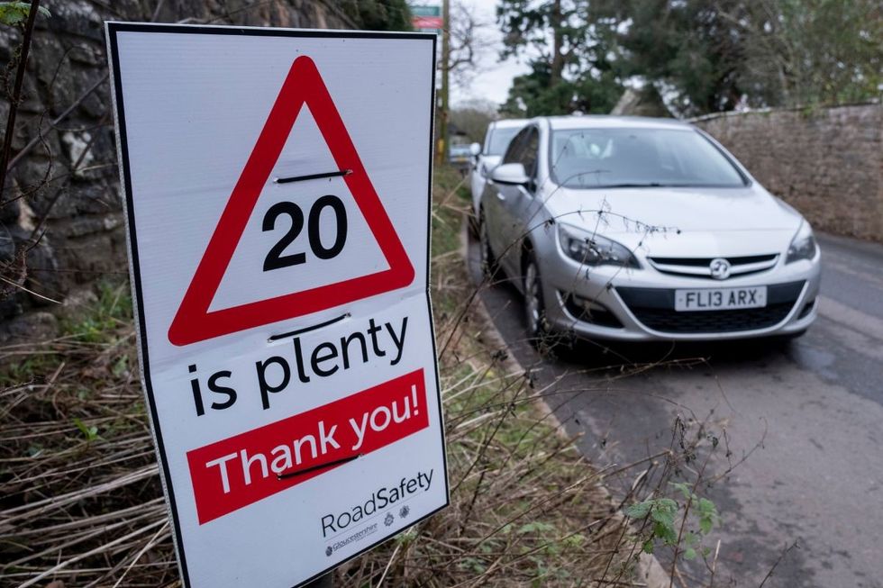 20mph speed limit sign with a car driving in the background