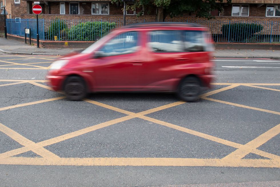 A car driving over a yellow box junction
