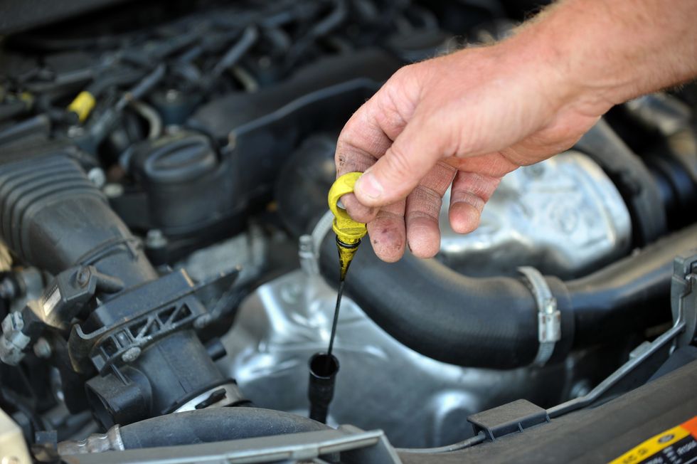 A driver checking his engine levels
