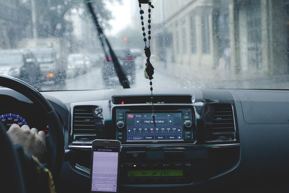 A driver with their phone in the car