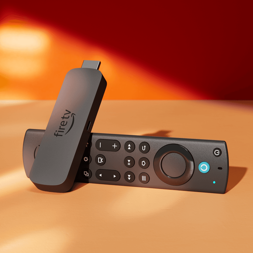 a fire tv stick pictured lying on its side in warm sunlight