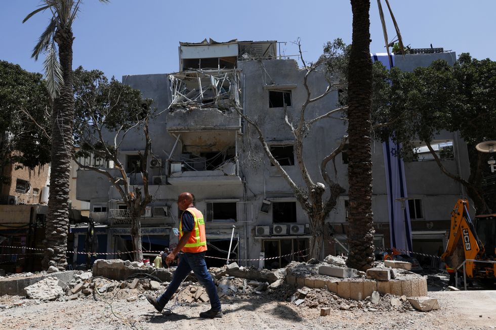 A first responder walks by an impact site following Iran's strike on Israel, amid the Iran-Israel conflict, in Haifa, Israel