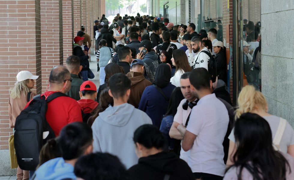 A long queue of migrants outside the Spanish Commission For Refugee Aid building