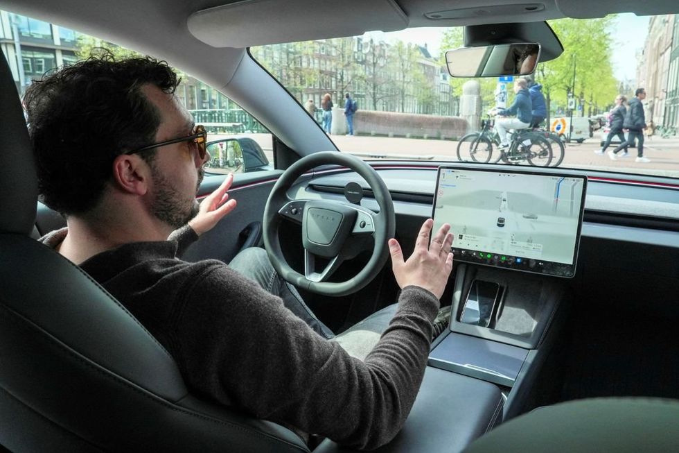 A man riding in a self-driving vehicle