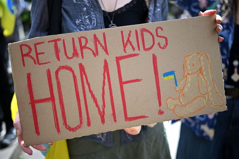 A sign reading 'return kids home'