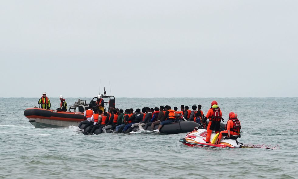 A small boat carrying migrants being met by authorities in the water