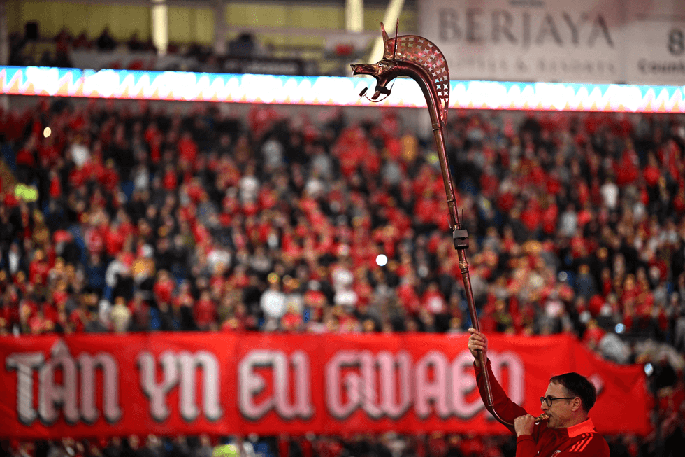 A trumpeter blasts a newly-built carnyx ahead of a Wales vs Belgium World Cup qualifying match