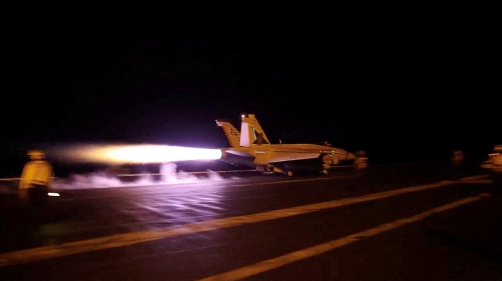 A US fighter jet takes off of an air carrier in strikes against Iran