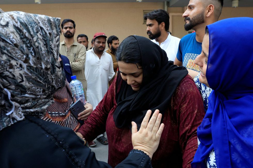 A woman named \u200bJaveria, whose newborn died in the fire, is consoled outside the hospital