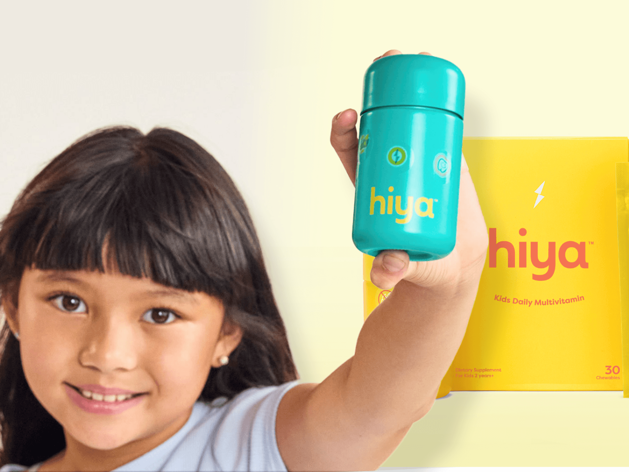 a young girl holds up a pot of Hiya children's supplements