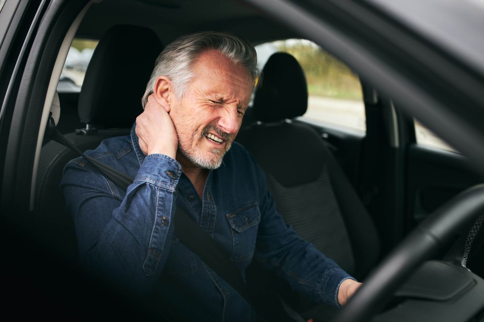 An elderly driver with a painful neck