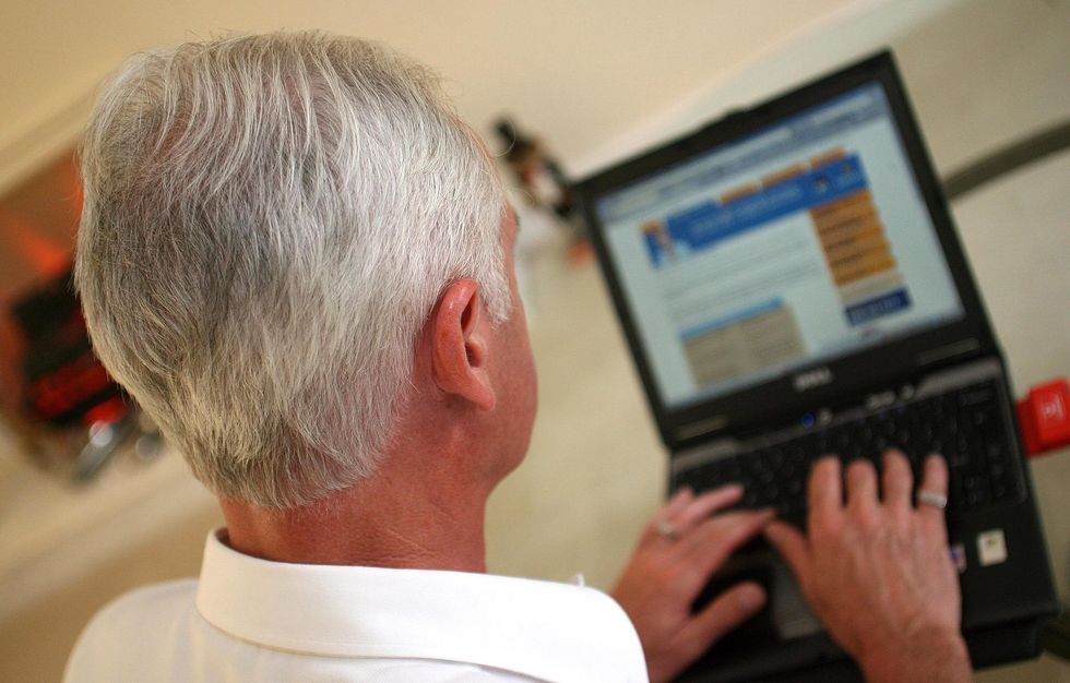 An elderly gentleman surfs the internet