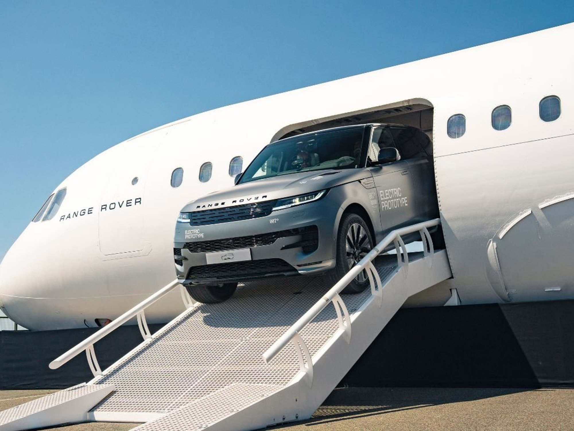 An electric Range Rover prototype leaving a Range Rover plane