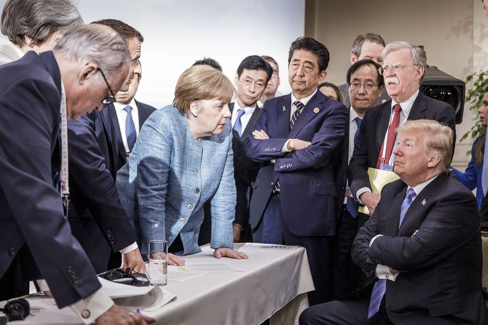 Angela Merkel standing over Donald Trump
