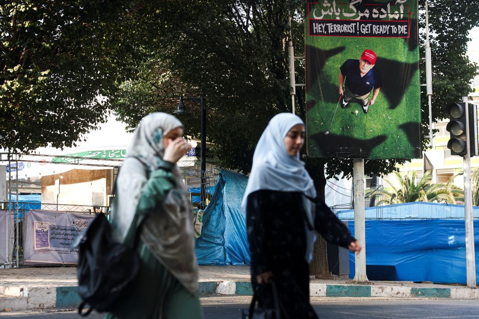 Banner of Donald Trump playing golf in Iran which reads 'hey terrorist! get ready to die'