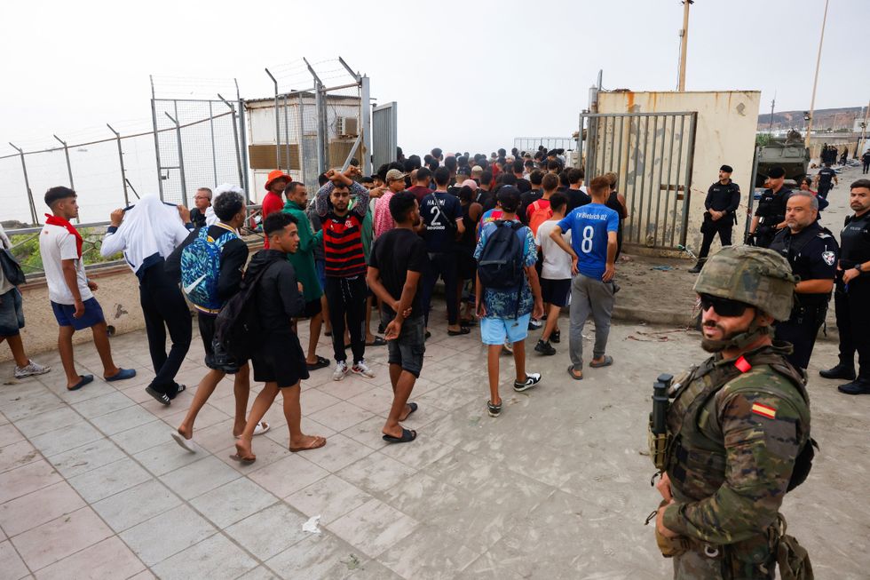 Ceuta migrants being escorted by Spanish authorities back to Morocco