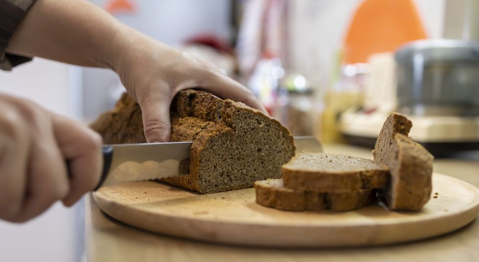 Cutting slices of brown bread