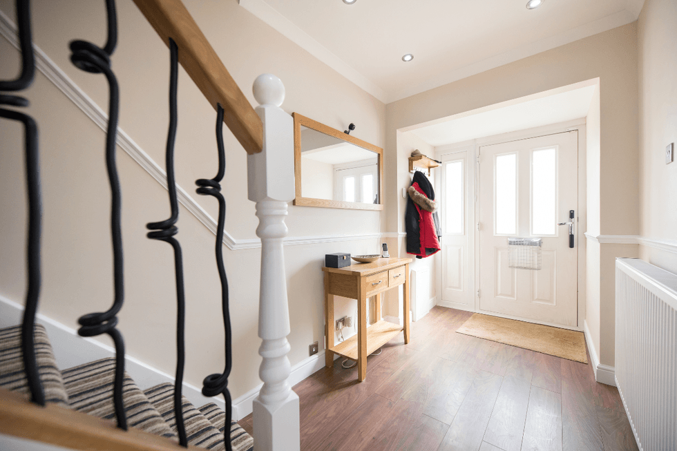 Decluttered hallway with door hooks and a hall table