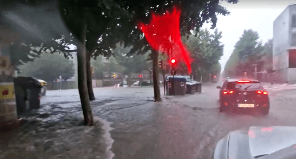 Drivers are seen forcing their cars out of the floodwater