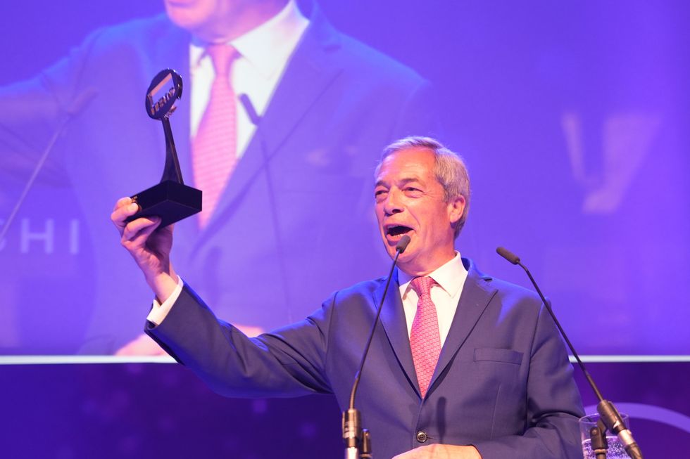 Farage holding up an award