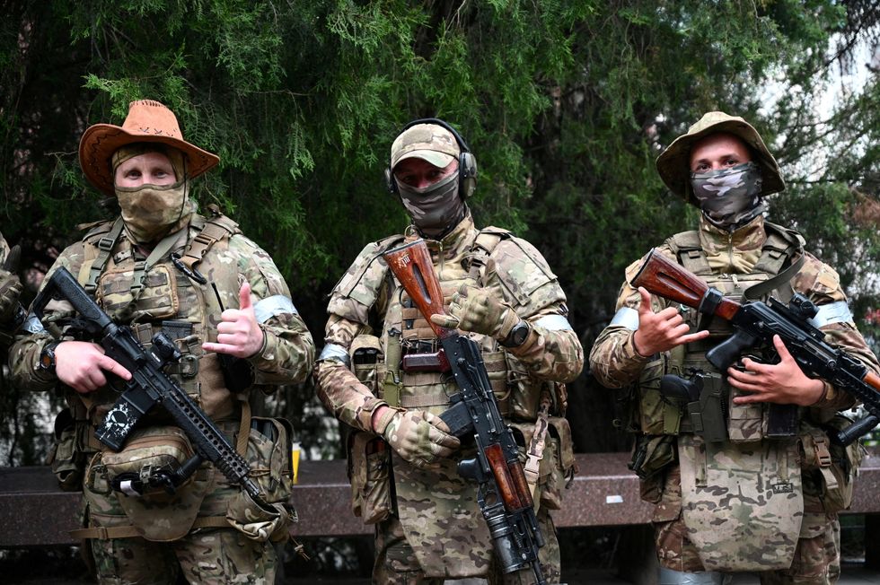 Fighters of Wagner private mercenary group pose for a picture as they get deployed near the headquarters of the Southern Military District in the city of Rostov-on-Don