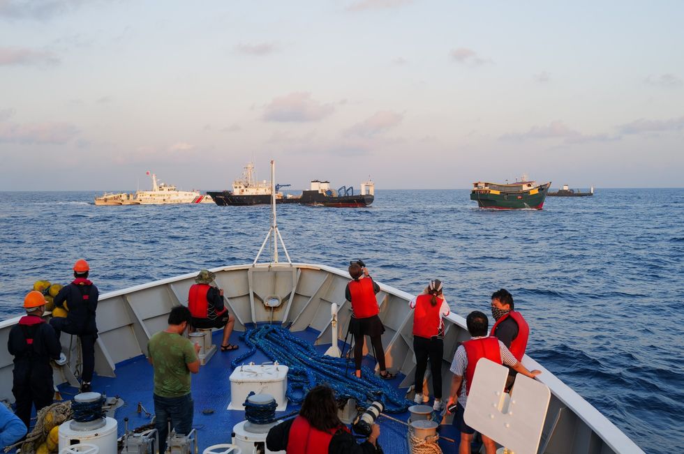 Filipino coast guard crews and journalists on board a ship