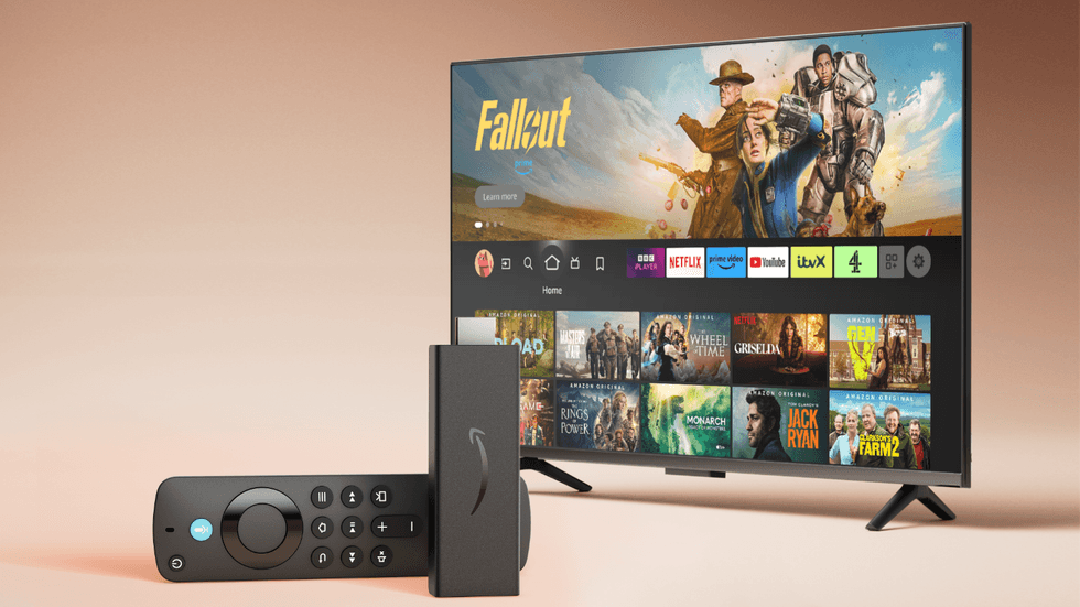 Fire TV Stick HD lying on its side with a television running FireOS in the background