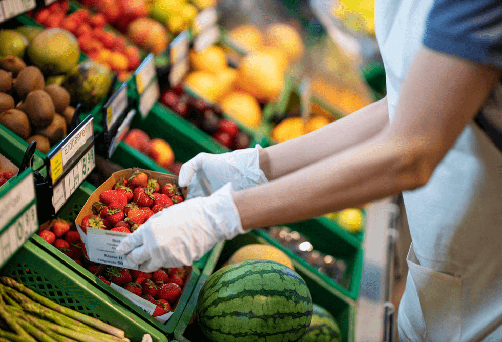 Grocer handling strawberries