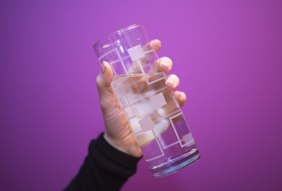 Hand holding glass of water