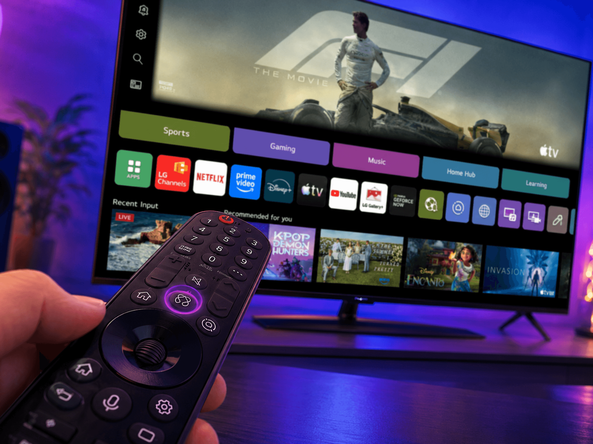 hand holds a tv remote control, with an LG 4K Smart TV pictured in the background