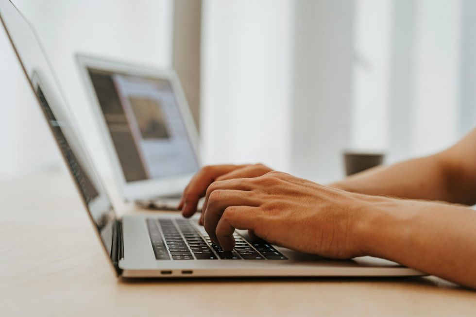 Hands typing on laptop