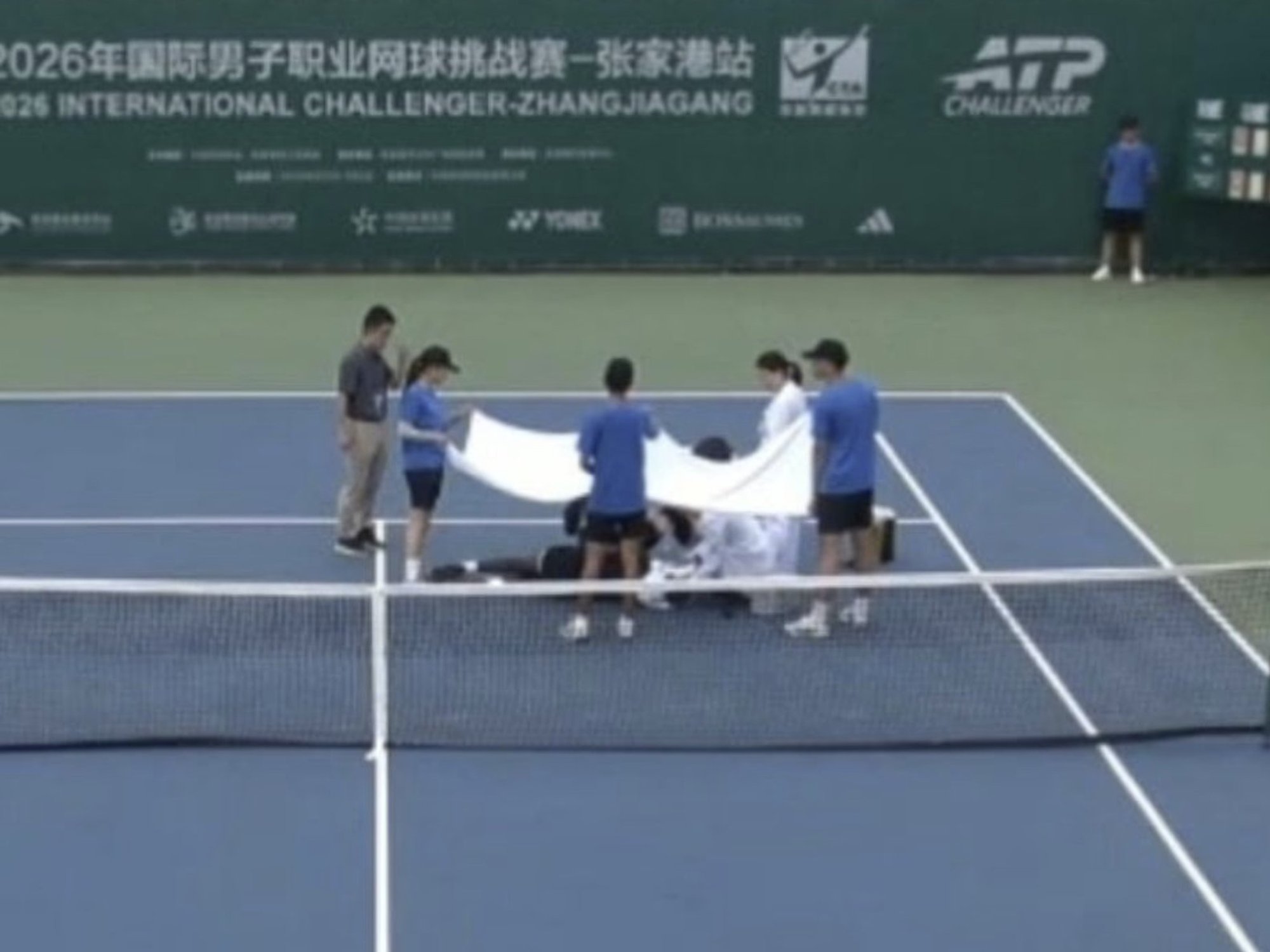 Tennis star collapses on court and covered in white towel in terrifying incident