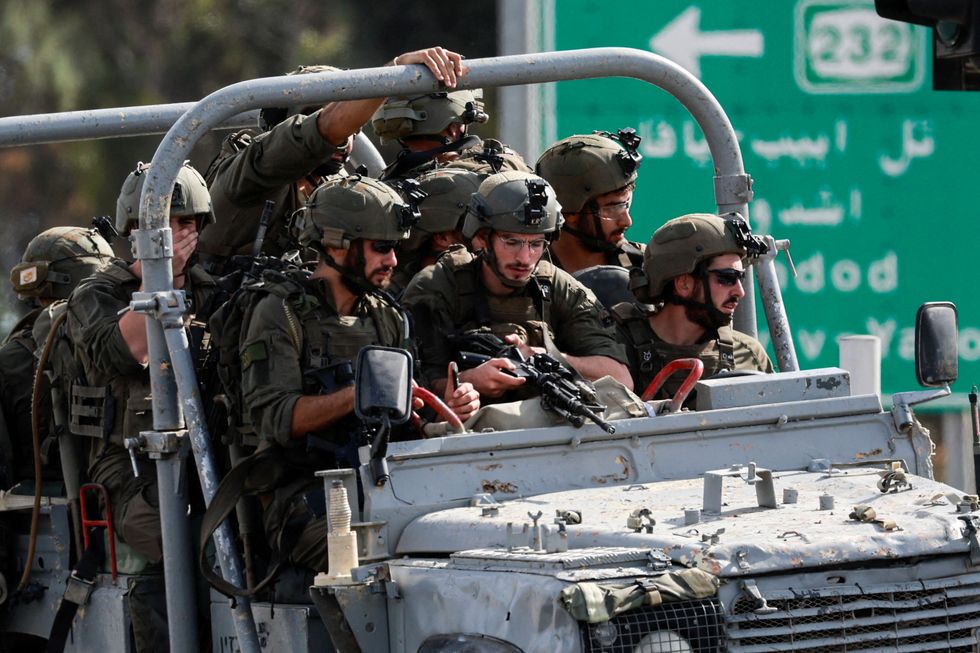 Israeli military drive on a road in southern Israel, as rockets are launched from the Gaza Strip