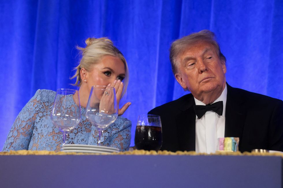 Karoline Leavitt \u200b(left) appears to whisper to Donald Trump (right)