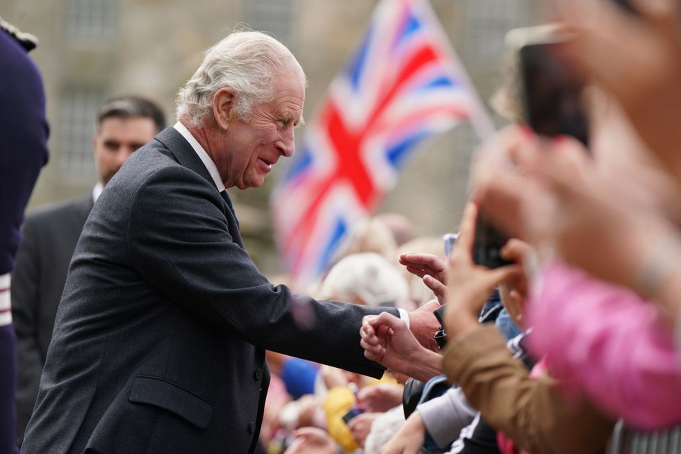 King Charles shaking hands with people in the crowd