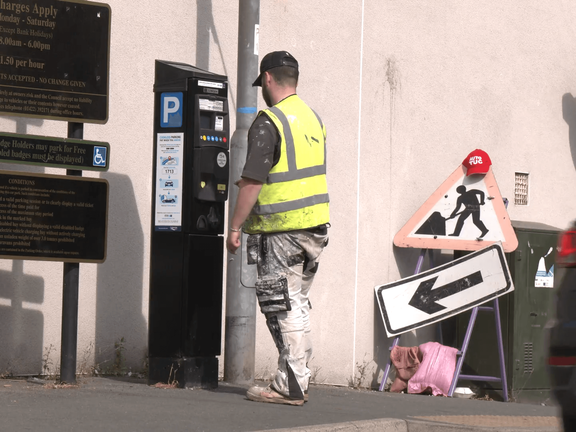 Man in high-viz paying for a parking ticket