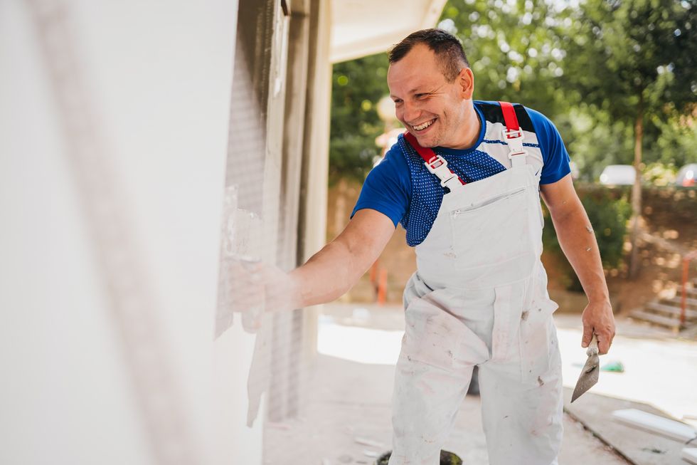 Man painting wall of house