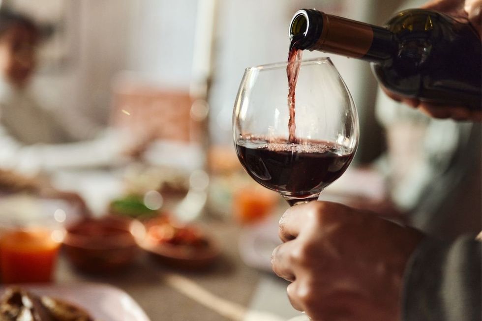 MAN POURING GLASS OF RED