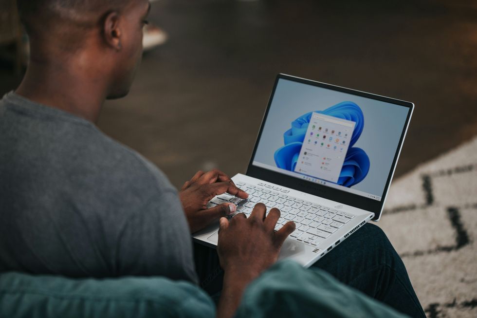 Man typing on Windows 11 laptop