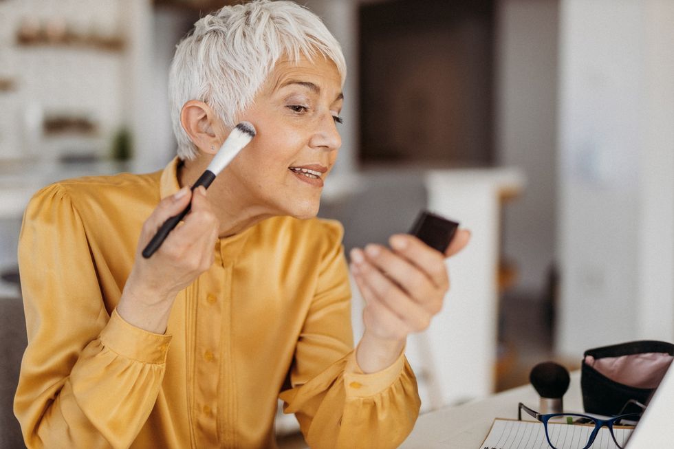 Mature woman applying makeup