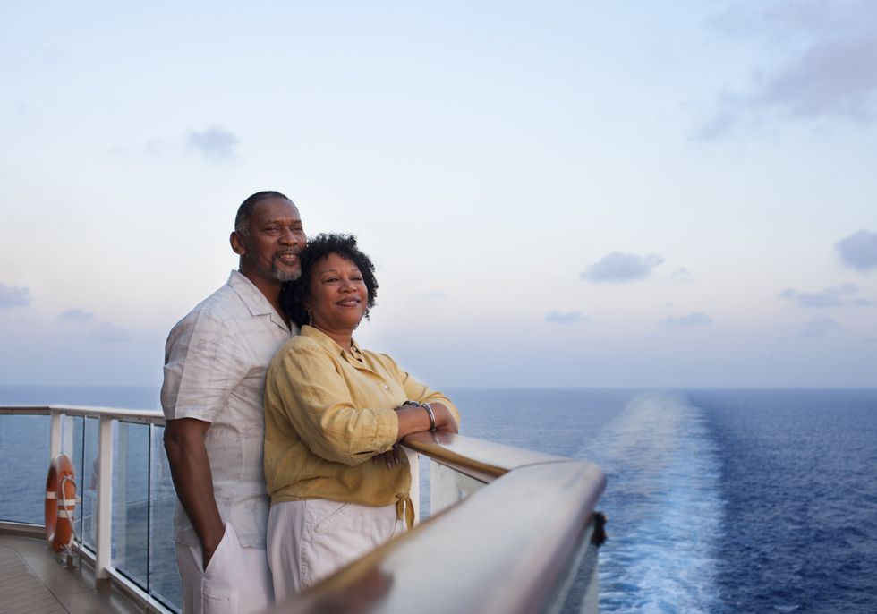 Middle age couple looking over balcony of cruise ship