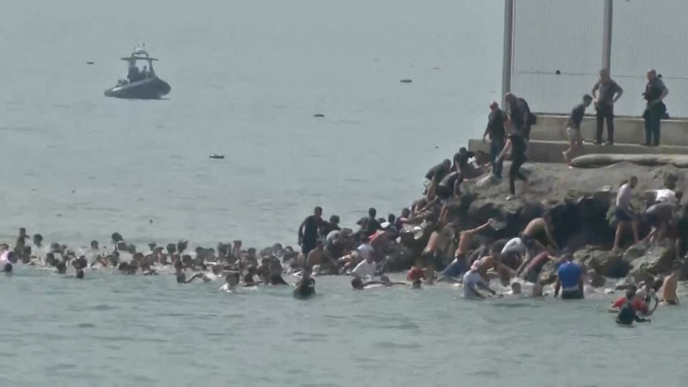 Migrants go from water into Ceuta