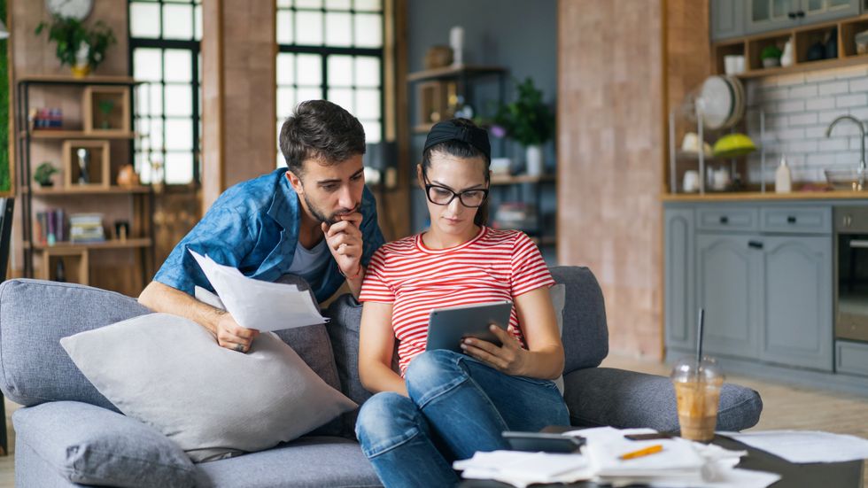 Mortgage holders look at tablet and statements