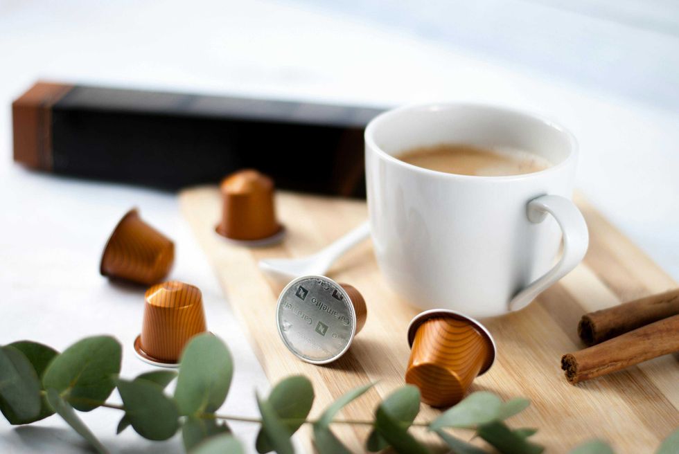 Nespresso coffee pods around white coffee cup