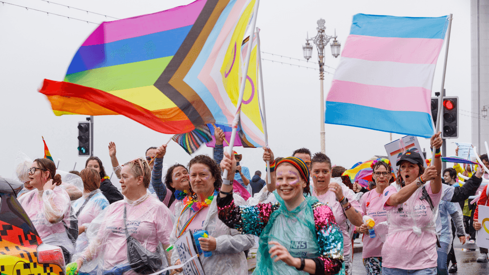 NHS workers hoisting the LGBTQ flag