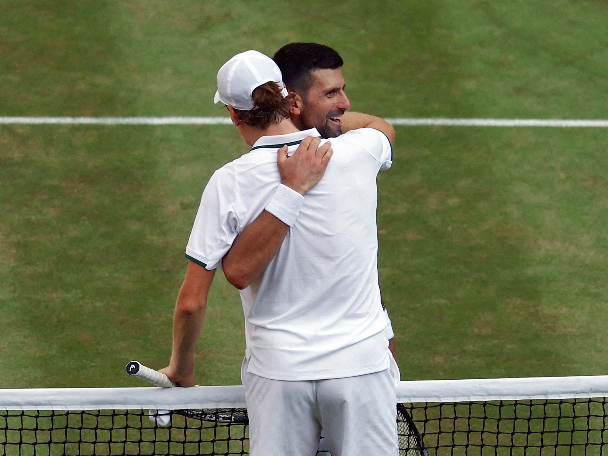 Novak Djokovic embraces Jannik Sinner at the net following his Wimbledon defeat
