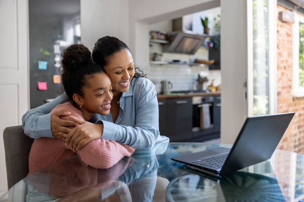 Parent and child look at laptop