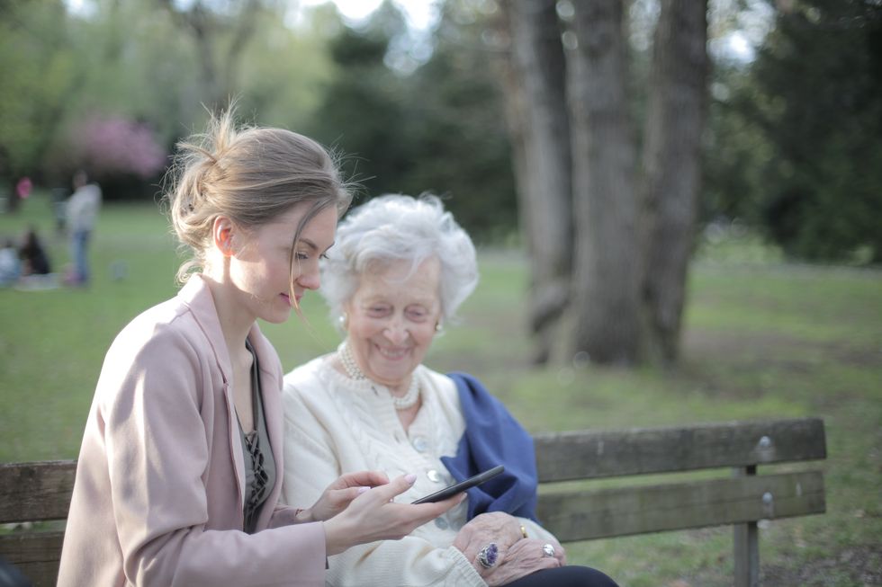 Pensioner and younger person looking at phone