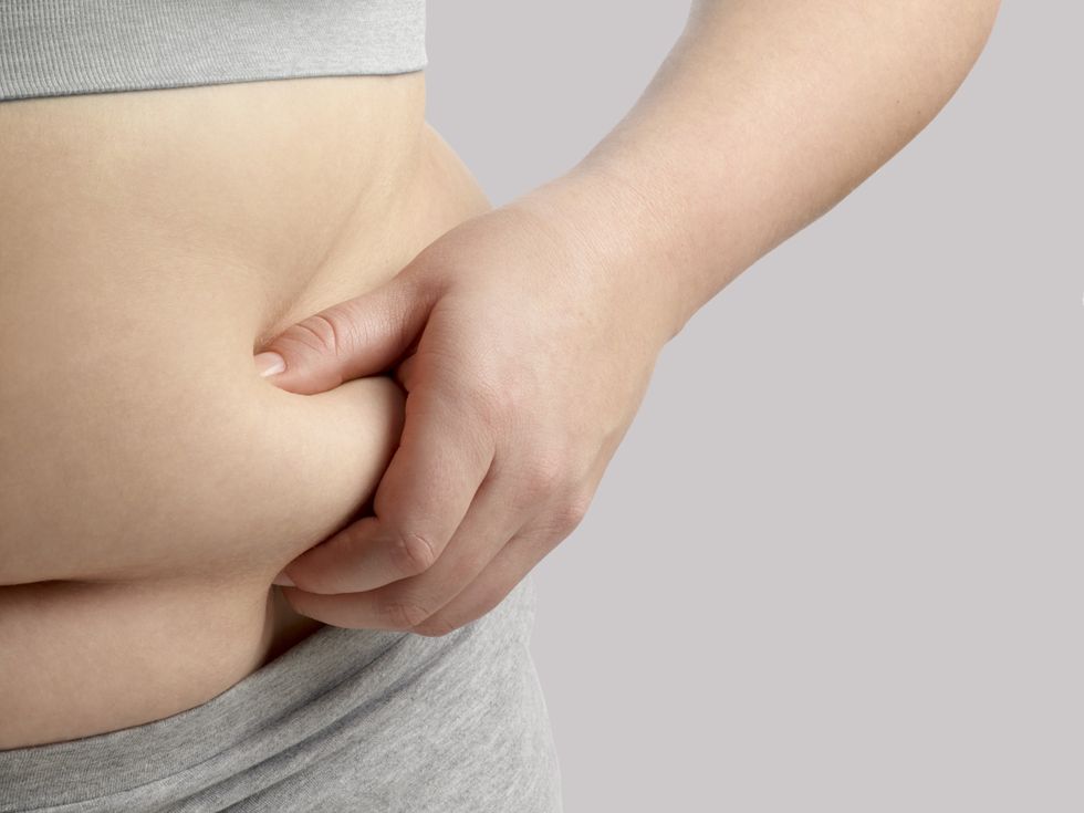 PERSON HOLDING THEIR BELLY FAT