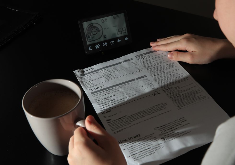 Person looks at energy bills statement and smart meter
